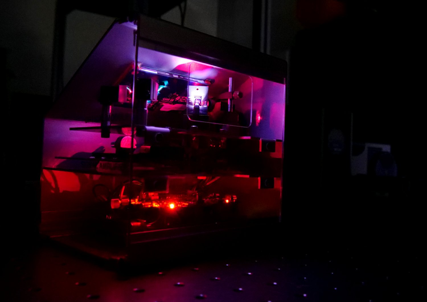 MEMS Mikrospiegel Labordemonstrator. Das Gerät leuchtet in Rot-Lila Farben