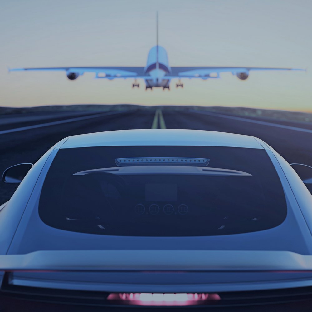 airplane flying above a car on the highway 