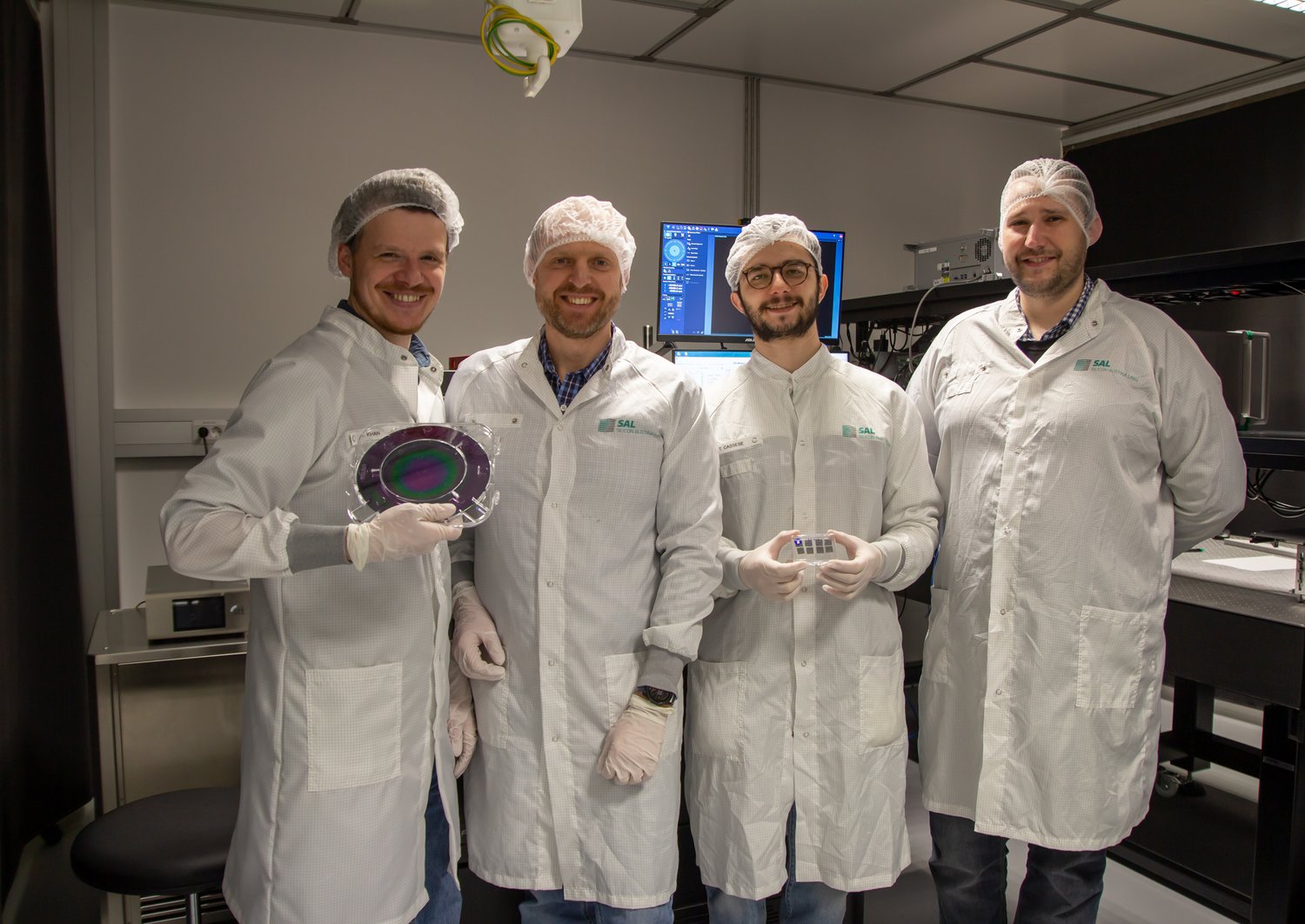 Gruppe von Forschern in weißen Mänteln im Labor