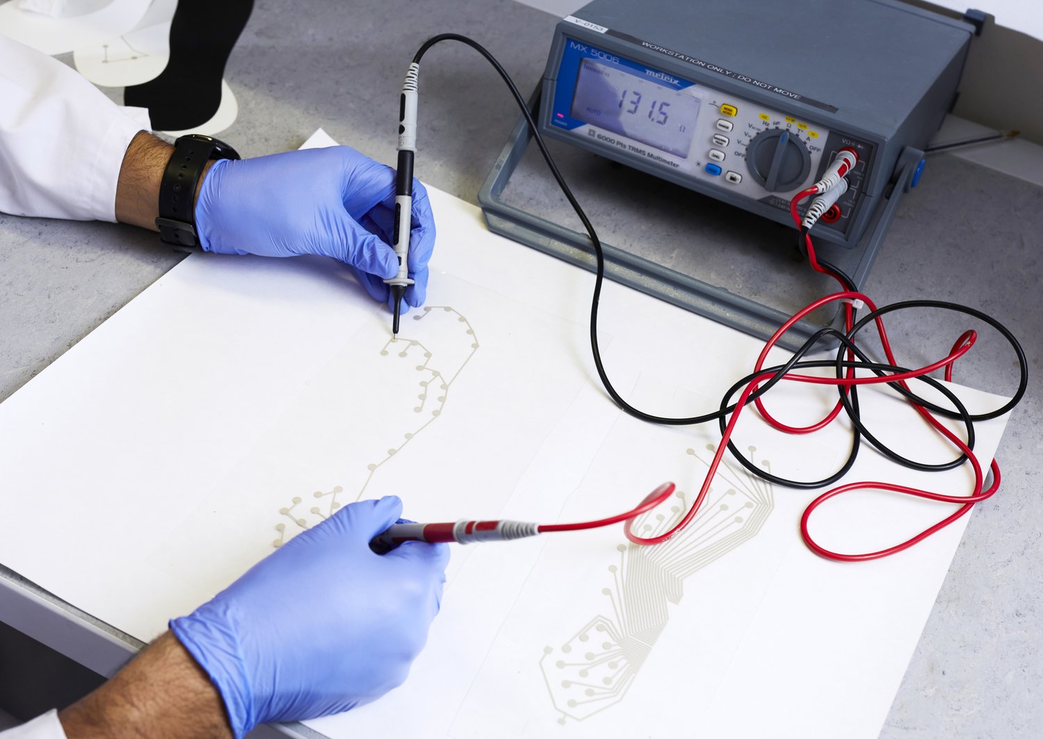 Close-up of the hands of a researcher working on a sensor sheet