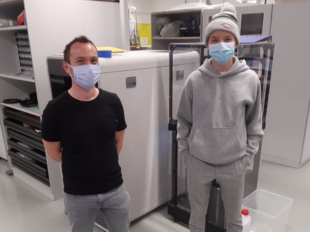 Ein Forscher und ein Jugendlicher stehen zusammen in einem Labor