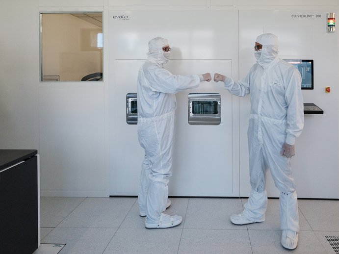 Two researchers standing in a clean room