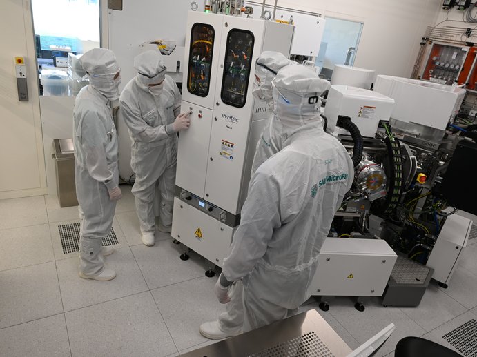 Researchers in front of the Evatec Clustertool in the Cleanroom