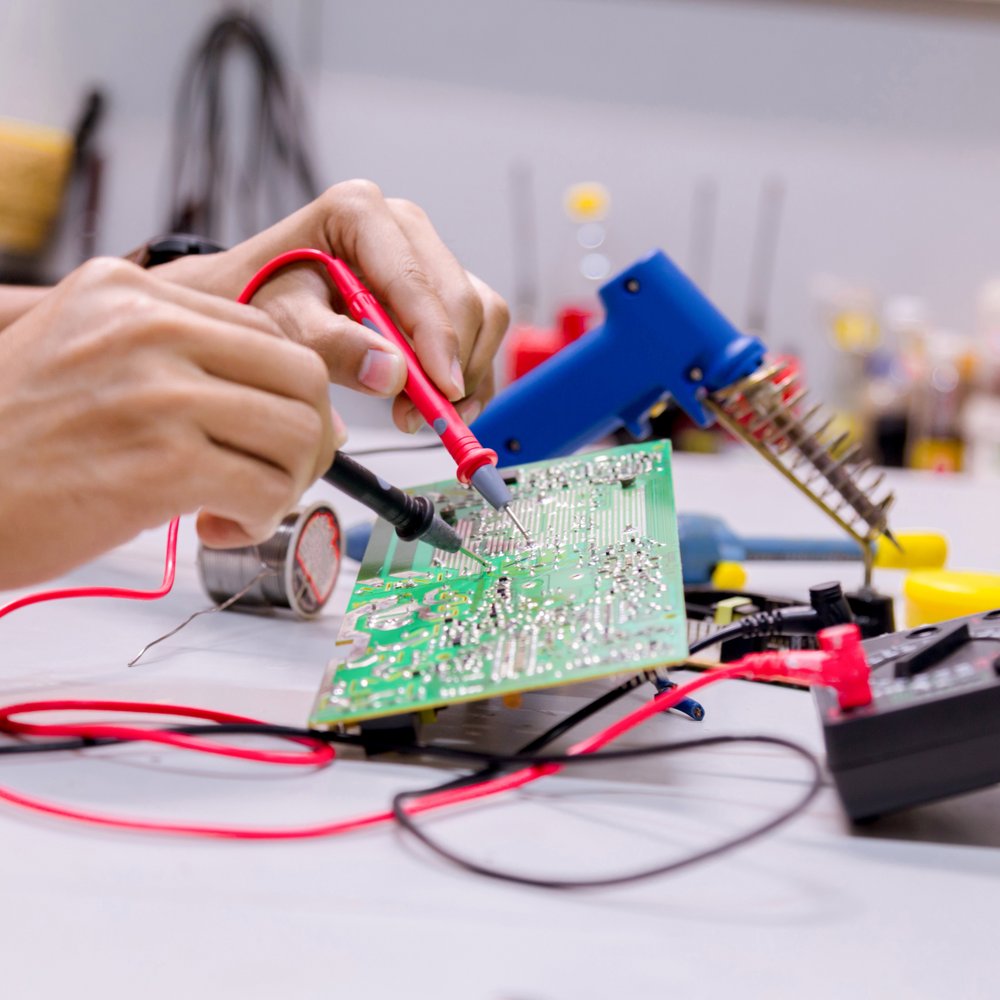 close-up of a person soldering a printed circuit board