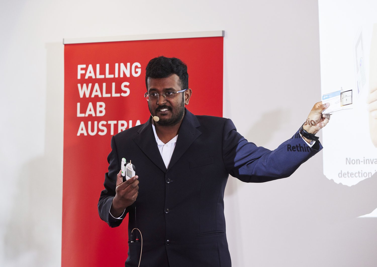 Mani in a suit, presenting at the Falling Walls Lab.