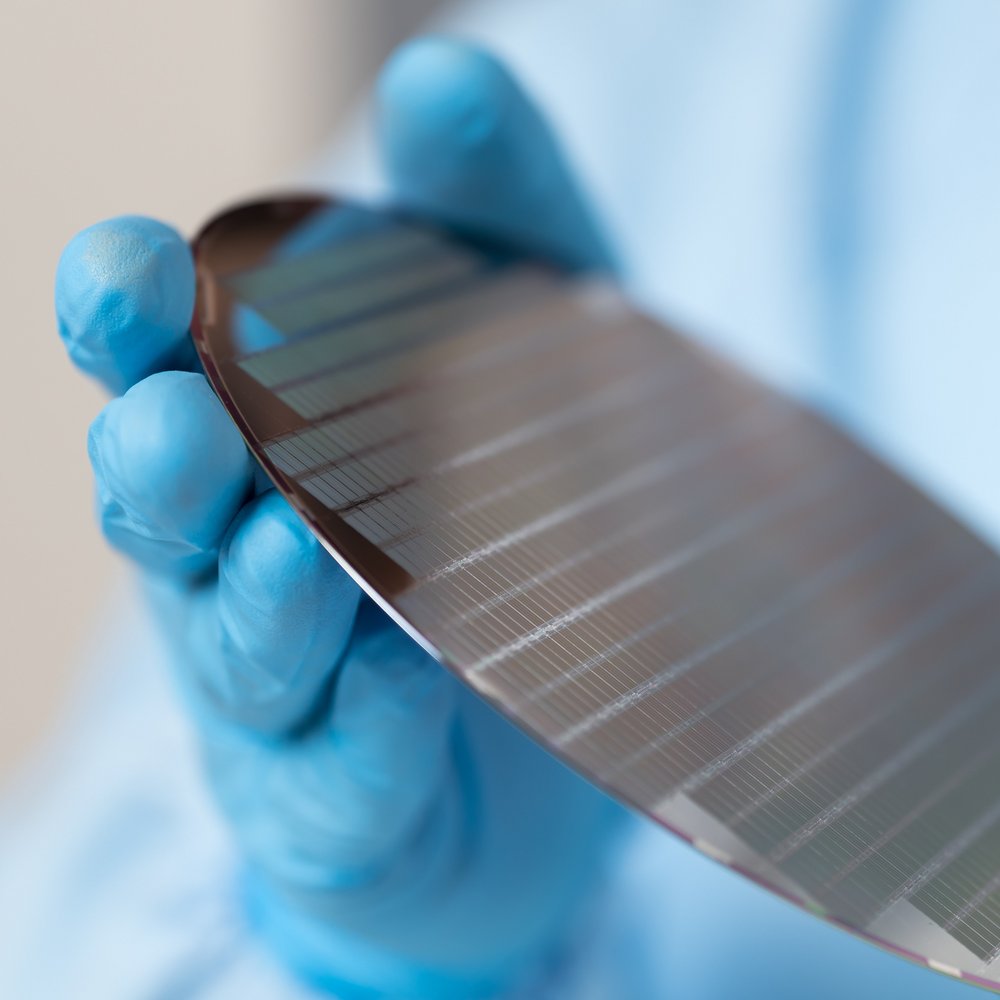 close-up of gloved hands which hold a wafer