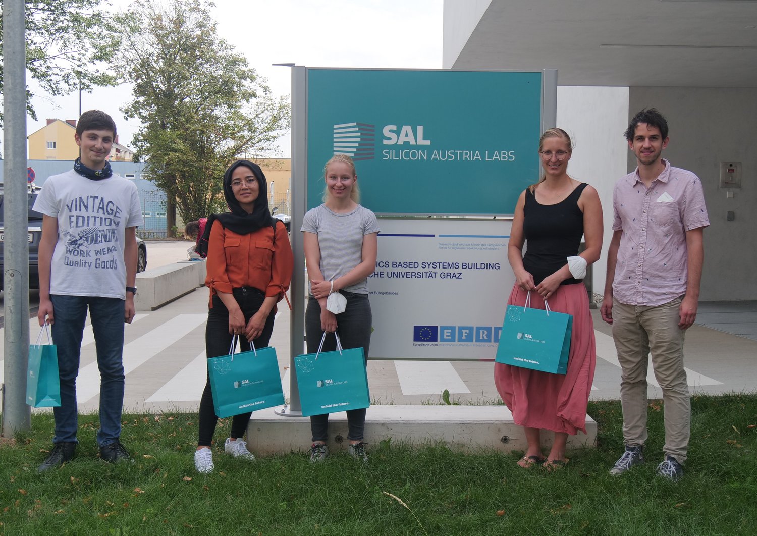 Five people standing in front of a SAL logo 