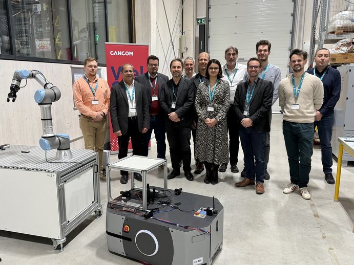 People are standing behind a robot in the lab