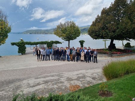 group picture of about 30 people in front of lake Wörthersee on a sunny day