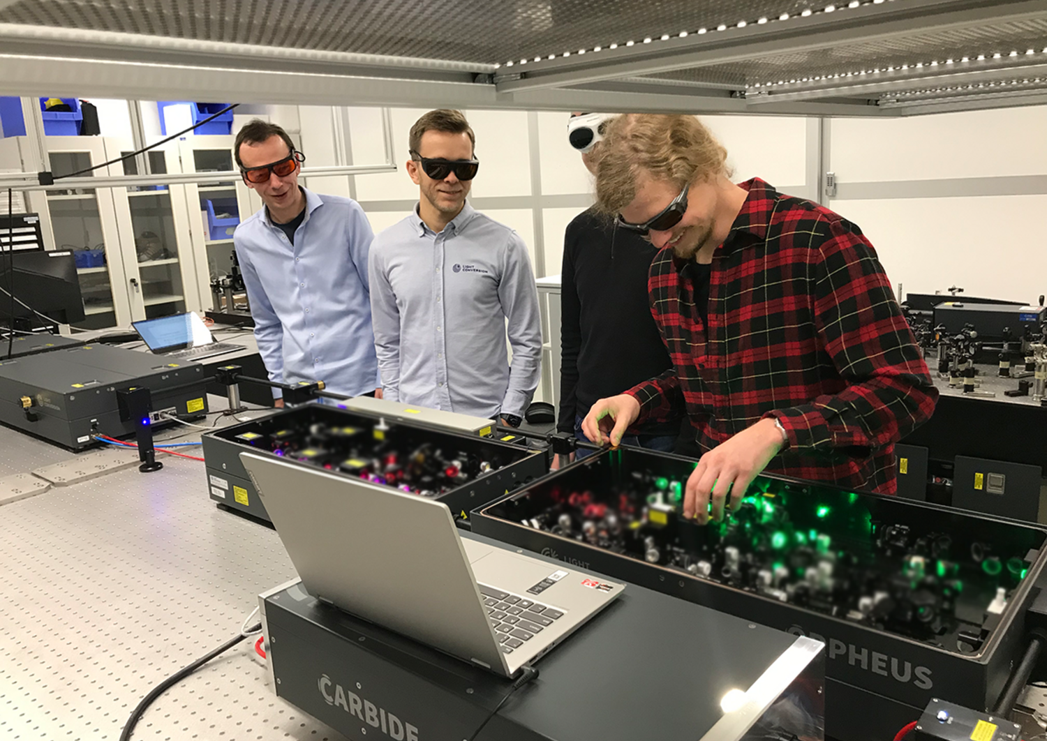four researchers at the FS Laser System in a lab
