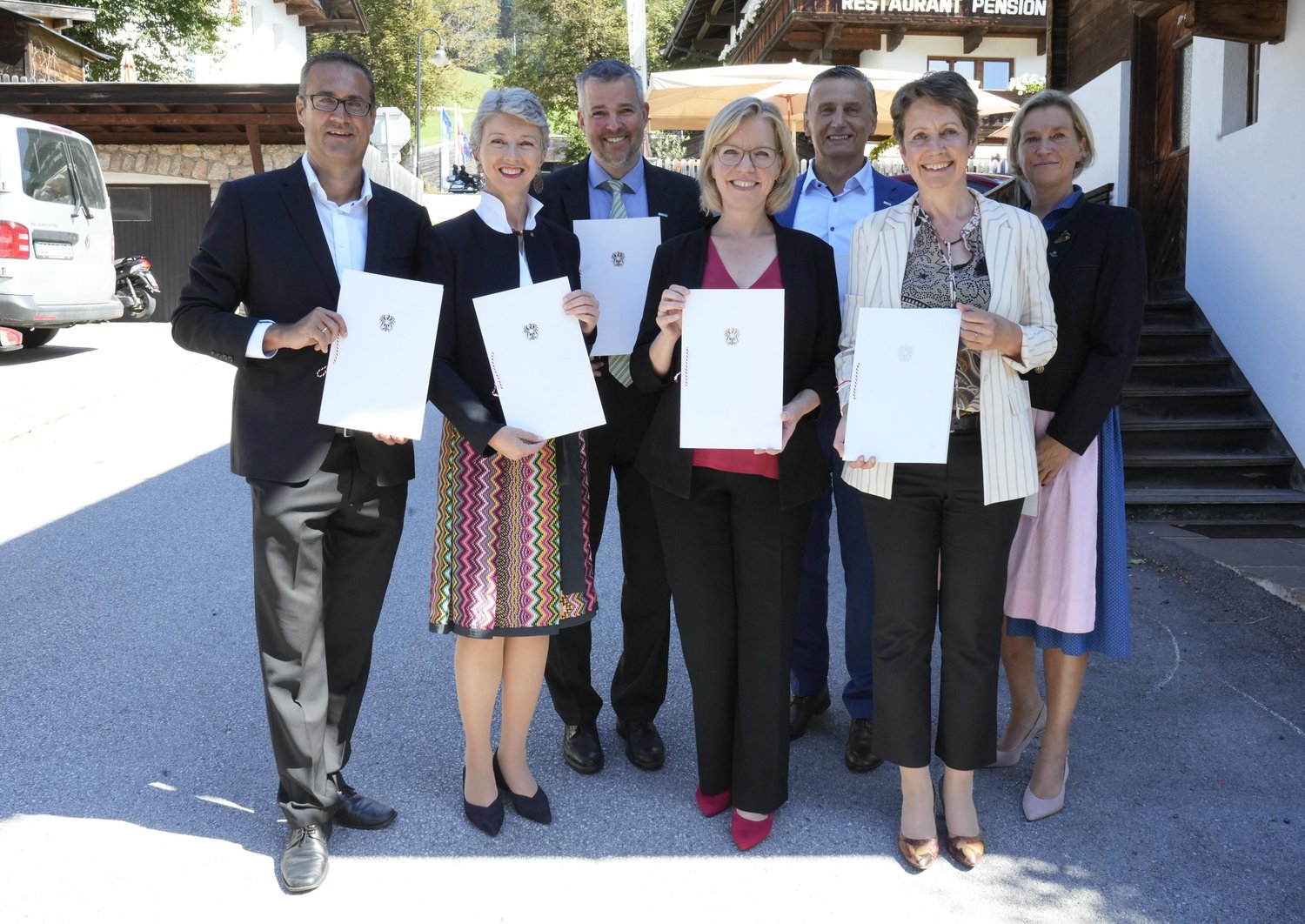 Christoph Ludwig, Gaby Schaunig, Gerald Murauer, Leonore Gewessler, Wilfried Enzenhofer, Sabine Herlitschka and Marion Mitsch, standing side by side with a declaration of continued support for the center of excellence until 2030 in their hands