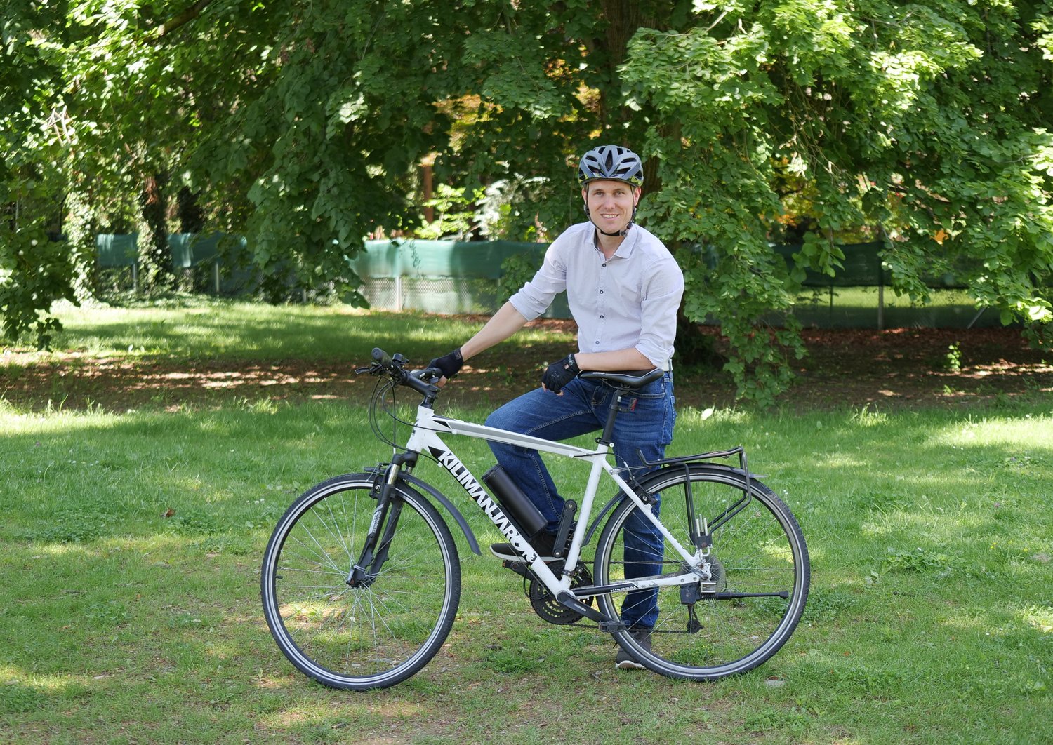 Herbert Hackl in bike clothing, leaning on his bike