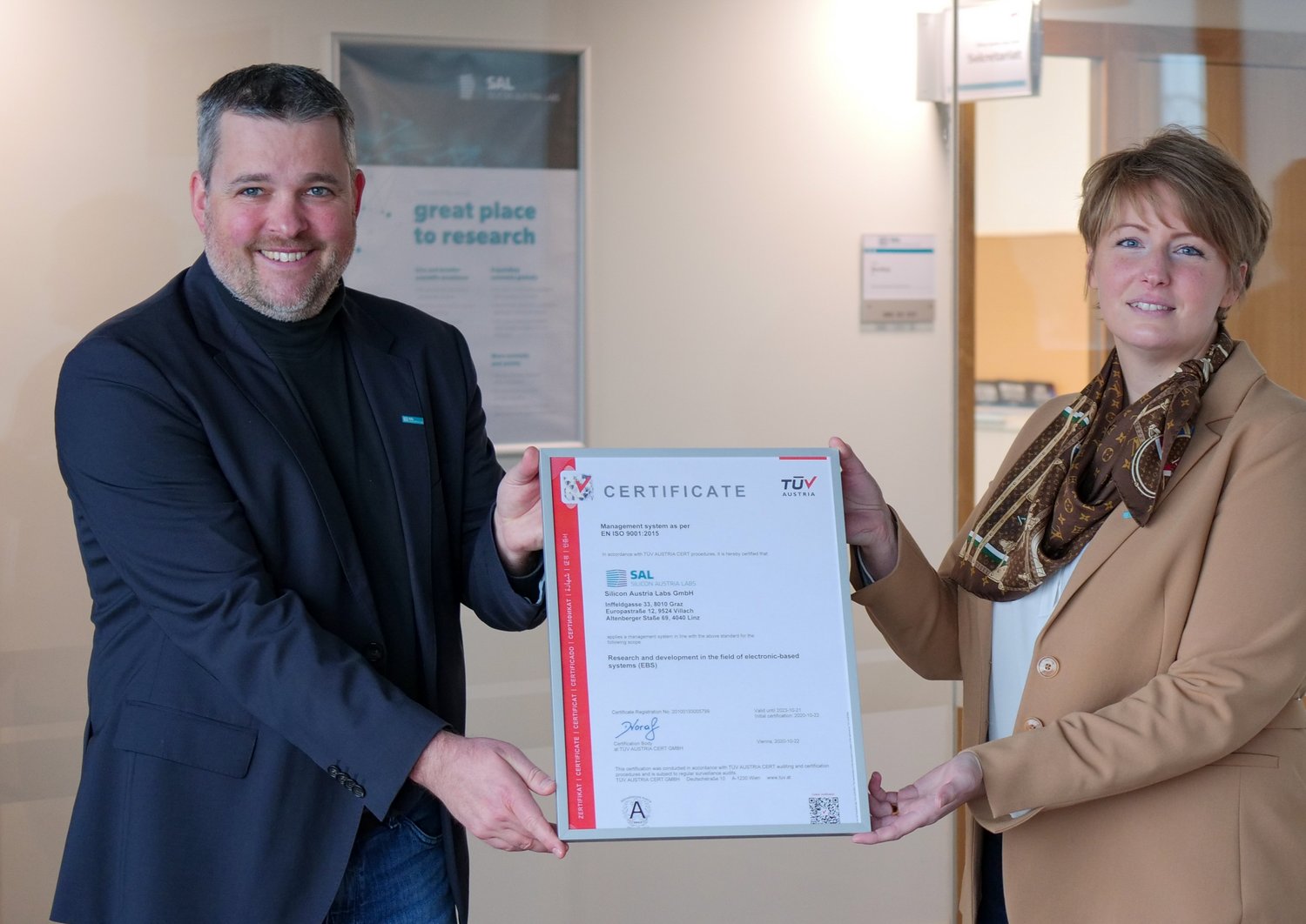 Two people are holding a certificate
