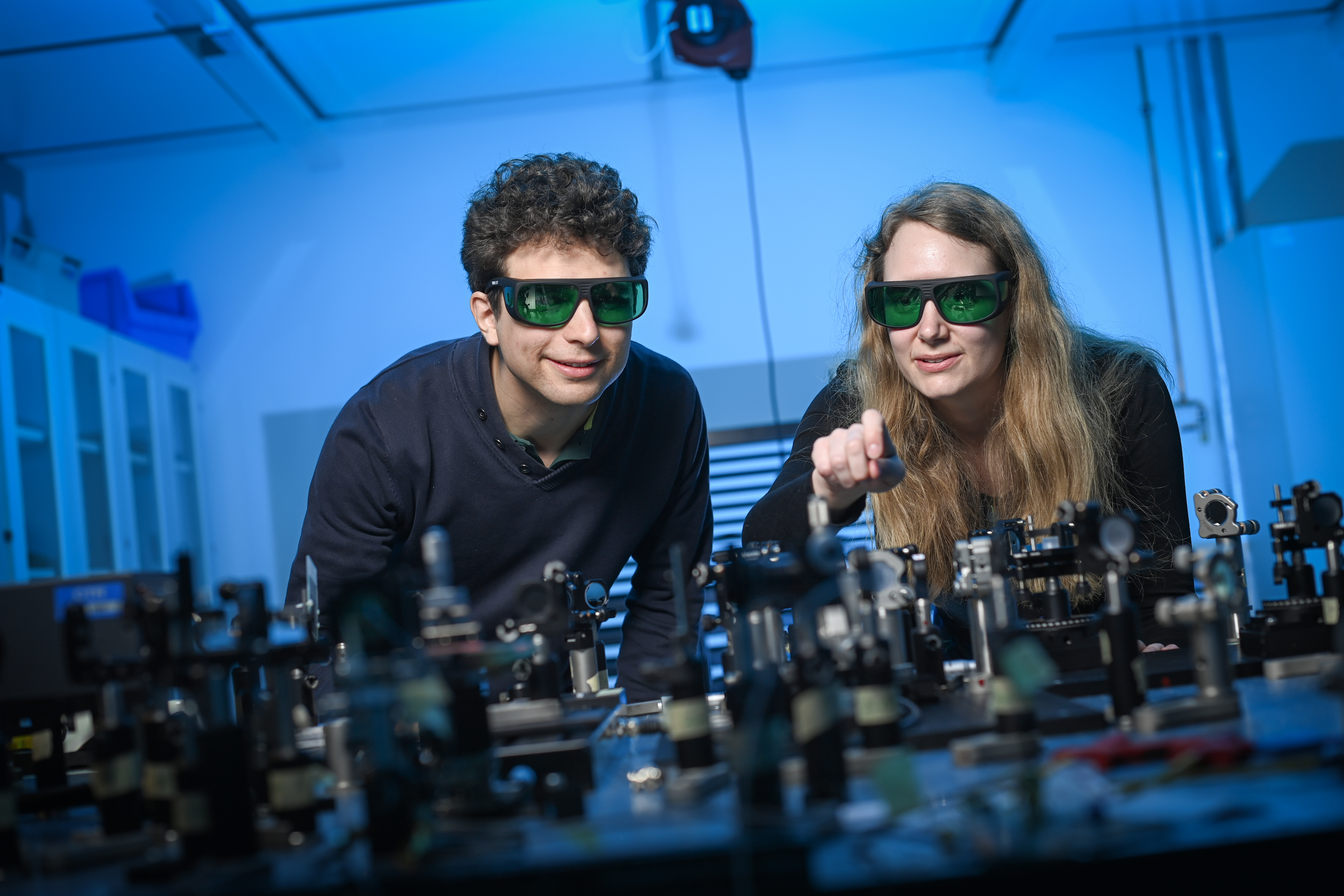 two researchers with safety goggles in a lab