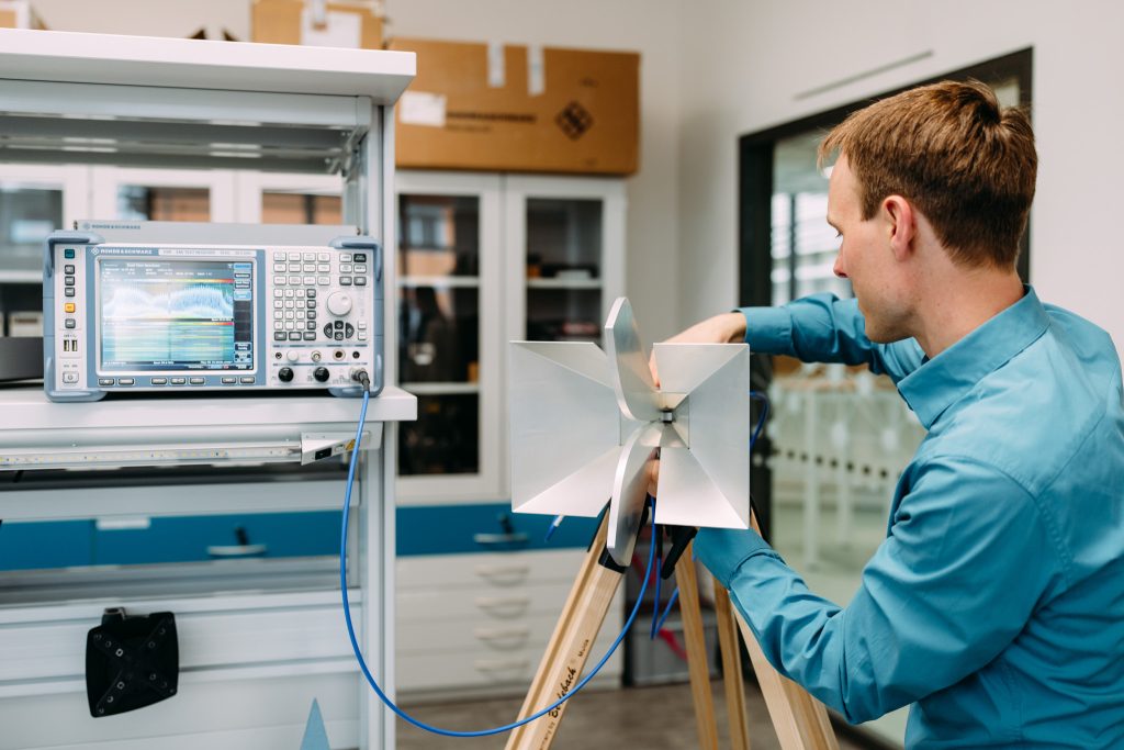 Ingenieur misst elektromagnetische Signale mit Antenne und Spektrumanalysator im Labor