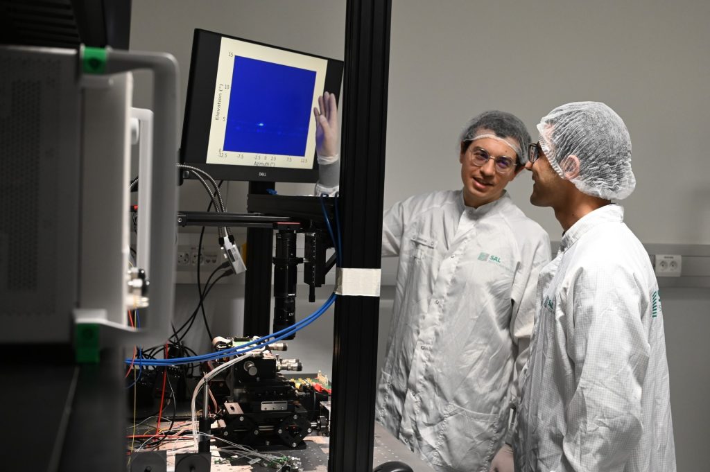 Zwei Forscher im Photonics Lab, die vor einem Bildschirm stehen und miteinander sprechen.