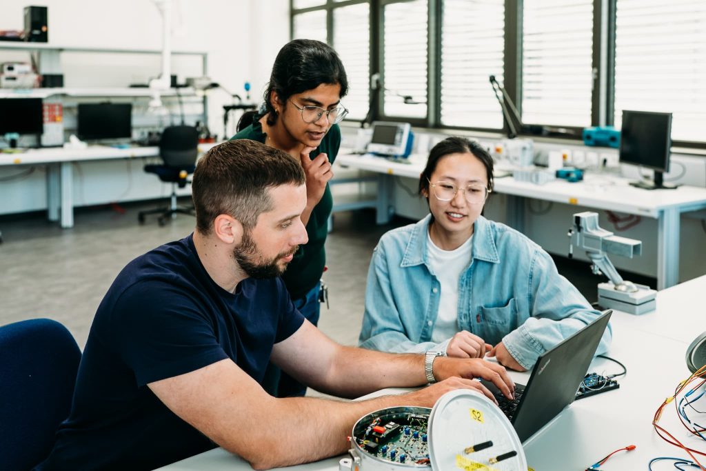 Drei Forscher:innen im Embedded Systems Labor.