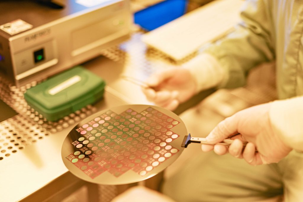 Hände, die einen Wafer in der Hand halten.