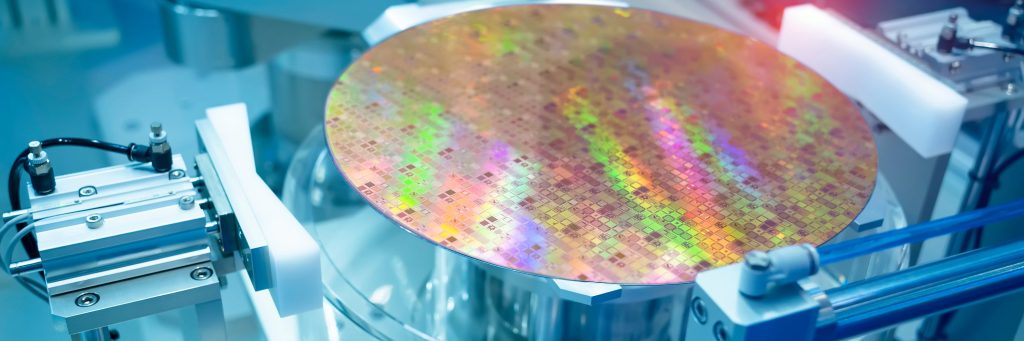 Halbleiter-Wafer mit schillernder Oberfläche in einer Fertigungs- oder Laboranlage.